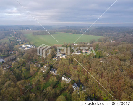 Aerial view of houses surrounded by forest in the country side area of Walloon, Belgium 86220047