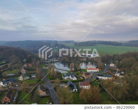 Aerial view of houses surrounded by forest in the country side area of Walloon, Belgium 86220060