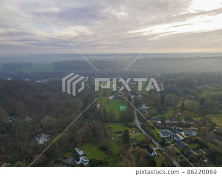 Aerial view of houses surrounded by forest in the country side area of Walloon, Belgium 86220069