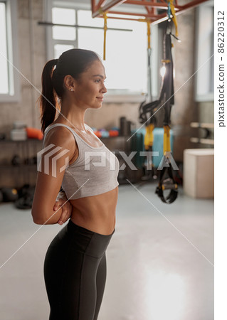 Young smiling woman standing in fitness club Young smiling woman standing in fitness club 86220312