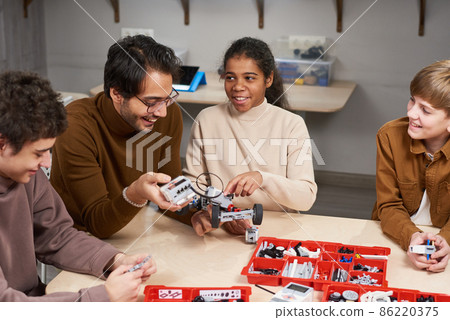 Children projecting robots with teacher 86220375