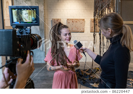 Young artist giving an interview at gallery Young artist giving an interview at gallery 86220447