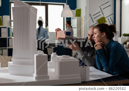 Team of two architect colleagues using smartphone in videocall conference 86220582