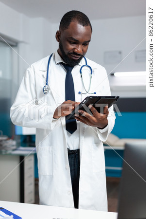 African american therapist doctor analyzing medicine prescription using tablet African american therapist doctor analyzing medicine prescription using tablet 86220617