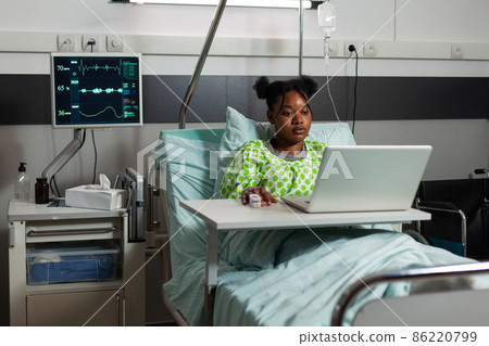 African american sick patient standing in bed during medical appointment 86220799