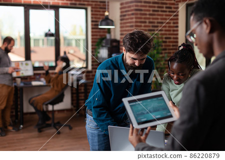 Multiracial businesspeople holding tablet computer with marketing turnover 86220879