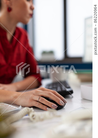 Closeup of hand using wireless computer mouse in startup office. 86220964