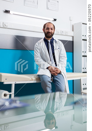 Portrait of specialist wearing uniform in medical cabinet Portrait of specialist wearing uniform in medical cabinet 86220970