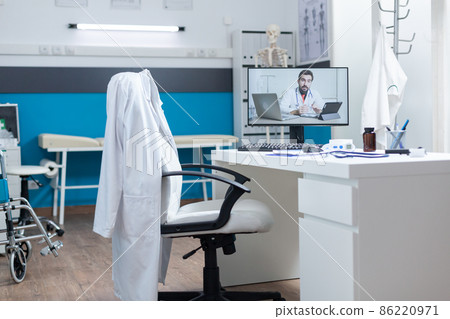 Empty medical office room with remote doctor having online videocall Empty medical office room with remote doctor having online videocall 86220971