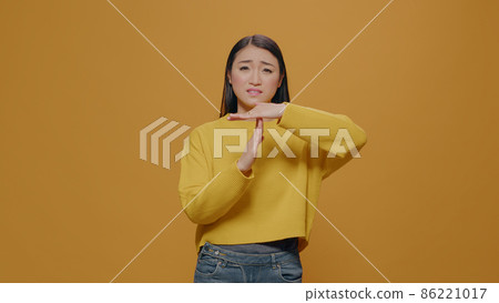 Tired woman doing timeout and break gesture in studio Tired woman doing timeout and break gesture in studio 86221017