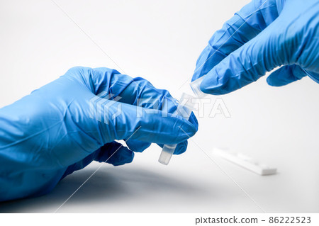 Man makes a covid-19 antigen pcr test macro. The test showed a positive result. 86222523