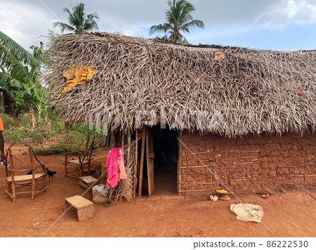 Local African village in summertime, clay houses and thatched roofs, banana trees. Travel and tourism concept 86222530