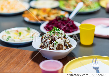 One whole head of roasted cauliflower with roasting ingredients and tahini sauce. Middle Eastern Health Diet. Mediterranean and Balkan food. 86222666