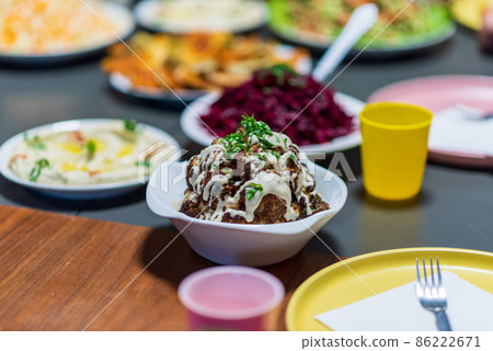 One whole head of roasted cauliflower with roasting ingredients and tahini sauce. Middle Eastern Health Diet. Mediterranean and Balkan food. 86222671