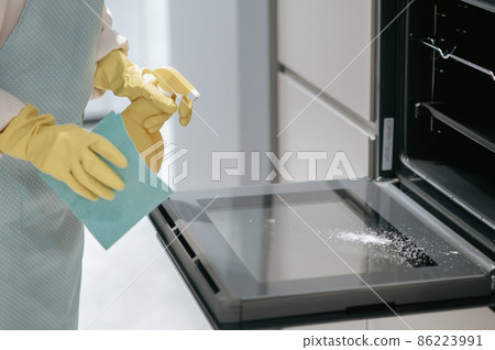 Service person cleaning the kitchen appliances 86223991