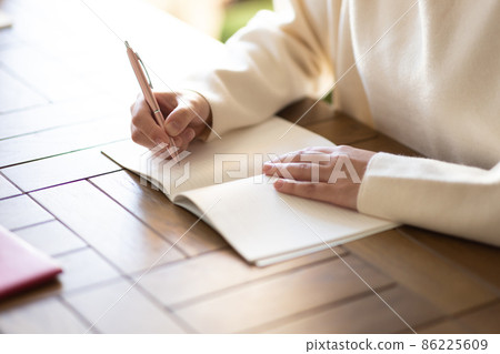 Female hand to fill in a notebook 86225609