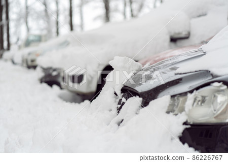 Snowfall in the city. Car covered in several inches of snow. Car almost totally buried Snowfall in the city. Car covered in several inches of snow. Car almost totally buried 86226767