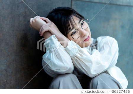 Young woman with glasses relaxing in the room Young woman with glasses relaxing in the room 86227436