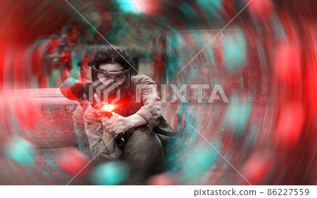 Portrait of asian female with gun on paintball field 86227559