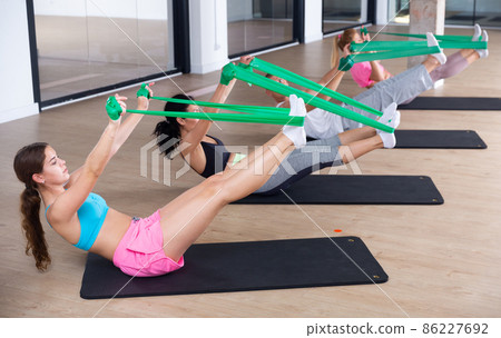 Active group of people performs exercises with the help of expander 86227692