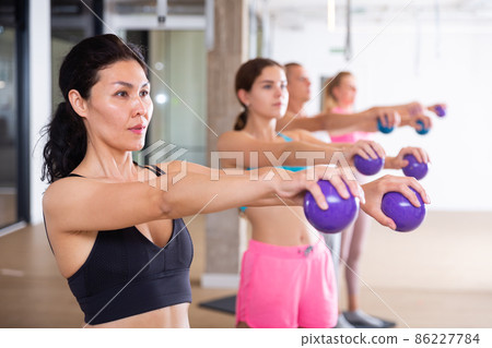 Young adult woman training with toning balls Young adult woman training with toning balls 86227784