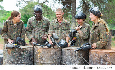 Smiling friends chatting after successful paintball match 86227876