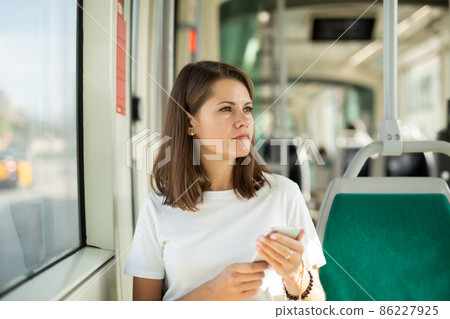 Woman using smartphone in public transport Woman using smartphone in public transport 86227925