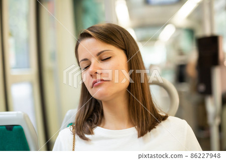Woman sleeping in modern streetcar 86227948