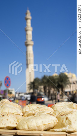 Egyptian fresh bread Aish Baladi against the mosque Egyptian fresh bread Aish Baladi against the mosque 86228073