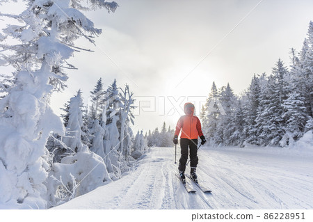 Winter outdoor active lifestyle concept. Girl holding snowball on snowy day with snowman in background on frozen lake at beautiful winter sunset Winter outdoor active lifestyle concept. Girl holding snowball on snowy day with snowman in background on frozen lake at beautiful winter sunset 86228951