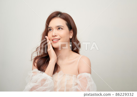 Beautiful portrait of asian young woman in white blouse on grey background. Beautiful portrait of asian young woman in white blouse on grey background. 86229332