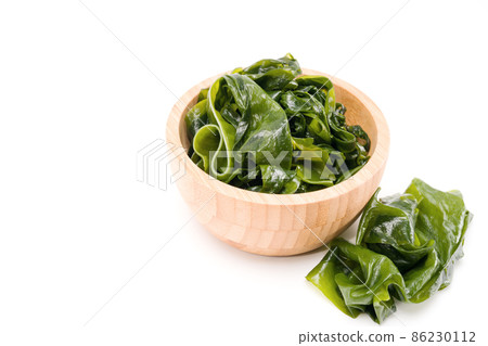 Fresh seaweed wakame in woodle bowl isolated on white background. Copy space. Japanese food Fresh seaweed wakame in woodle bowl isolated on white background. Copy space. Japanese food 86230112