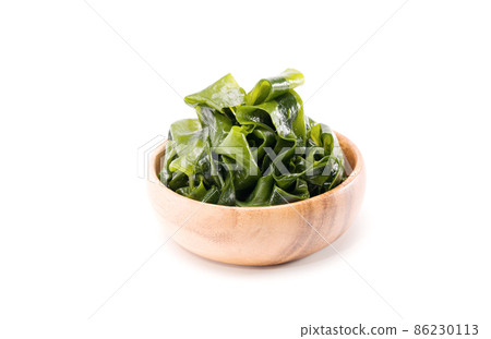 Fresh seaweed wakame in woodle bowl isolated on white background. Copy space. Japanese food Fresh seaweed wakame in woodle bowl isolated on white background. Copy space. Japanese food 86230113