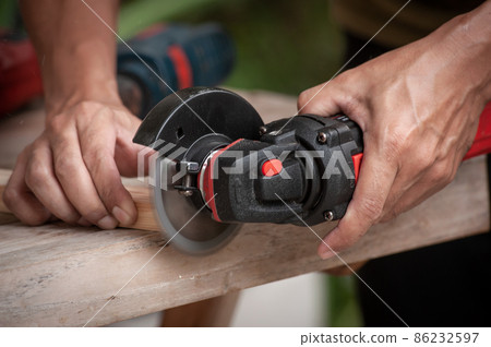 Close up of a carpenter using a circular saw to cut a wood, Carelessness at work concept Close up of a carpenter using a circular saw to cut a wood, Carelessness at work concept 86232597