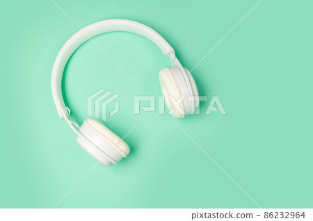 Top view of white wireless headphones isolated on green mint background. 86232964