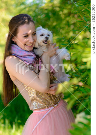 Puppy white dog with it's owner. Concept about friendship, animal and freedom. Puppy white dog with it's owner. Concept about friendship, animal and freedom. 86233300