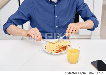 Closeup view of man eating omelet 86233734
