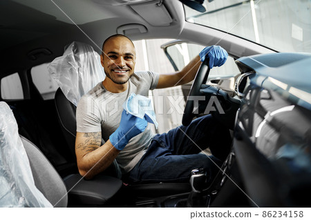 A man cleaning car interior, car detailing in Carwash service A man cleaning car interior, car detailing in Carwash service 86234158
