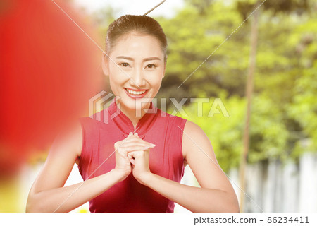 Asian Chinese woman in a cheongsam dress with congratulations gesture 86234411