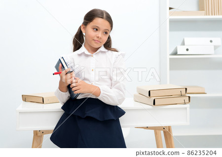 Ready for lesson. Girl child holds book while stand near 86235204