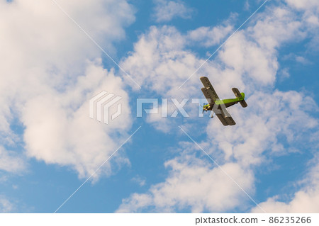 Biplane flying in blue sky at Air Show Biplane flying in blue sky at Air Show 86235266