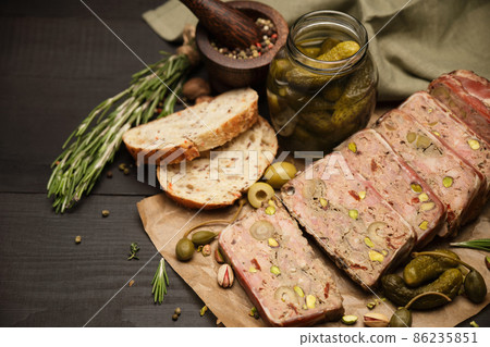 Sliced Traditional French terrine covered with bacon on dark wooden background Sliced Traditional French terrine covered with bacon on dark wooden background 86235851