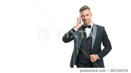 smiling businessman in tuxedo speak on phone isolated on white background with copy space smiling businessman in tuxedo speak on phone isolated on white background with copy space 86236036