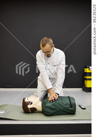 The doctor demonstrates first aid skills. Heart massage 86236329