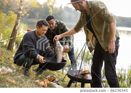 Man put big fish in cauldron for cooking Ukha soup Man put big fish in cauldron for cooking Ukha soup 86236345