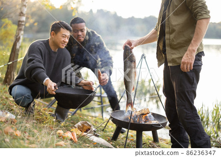 Man put big fish in cauldron for cooking Ukha soup 86236347