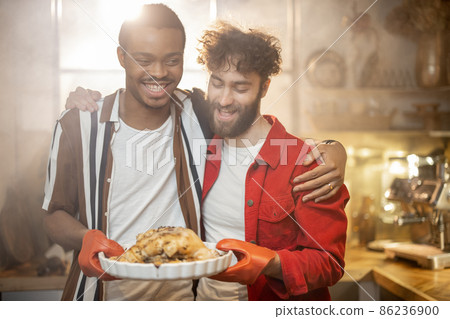 Two guys with cooked meal together on kitchen Two guys with cooked meal together on kitchen 86236900