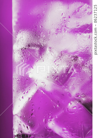 Ice cubes in a glass with refreshing ice water on a pink background. Ice cubes in a glass with refreshing ice water on a pink background. 86237125