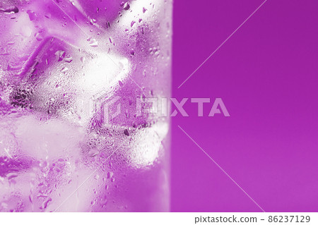 Ice cubes in a glass with refreshing ice water on a pink background. Ice cubes in a glass with refreshing ice water on a pink background. 86237129