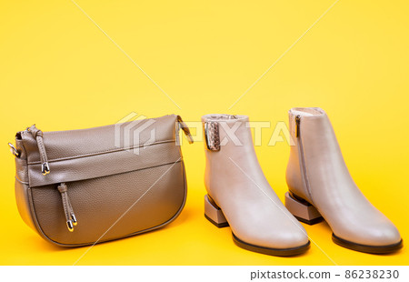 beige boots. ankle boots on yellow background. shoe store. shopping concept. beige boots. ankle boots on yellow background. shoe store. shopping concept. 86238230
